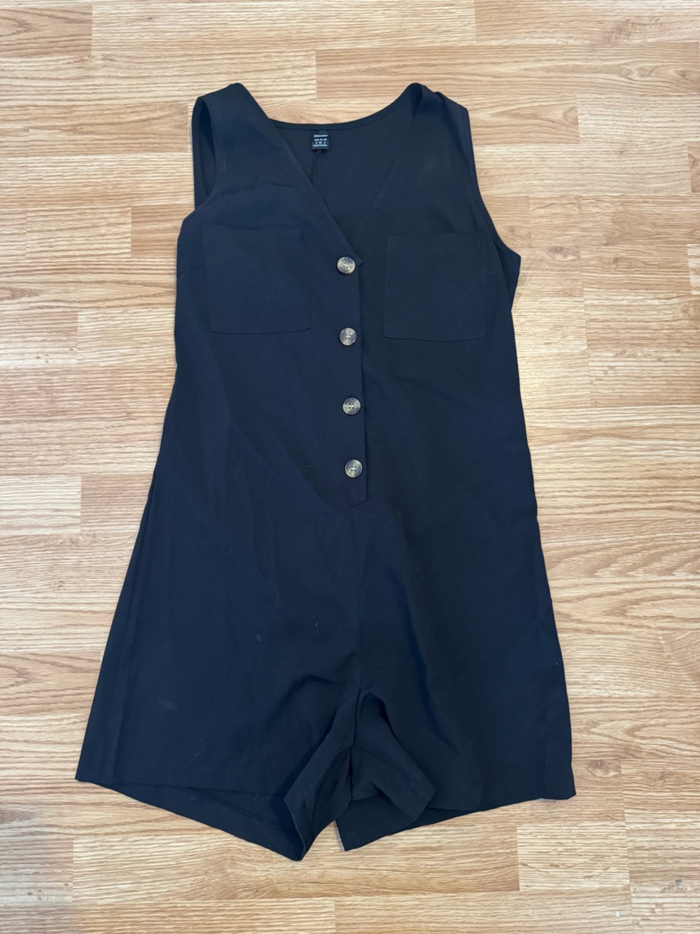 Women’s V-neck black romper with brown accent buttons